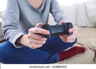 man holding a joystick controllers while playing a video games at home