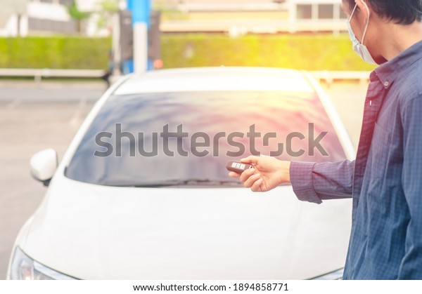 Man holding key opening car\
door
