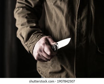 Man Holding A Knife In A Threatening Stance Ready To Fight