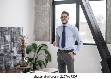 Man holding laptop looking at camera - Shutterstock ID 2187669307