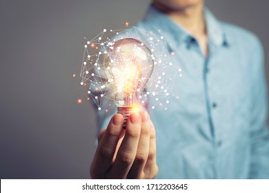 Man holding light bulbs, ideas of new ideas with innovative technology and creativity. concept creativity with bulbs that shine glitter. - Shutterstock ID 1712203645