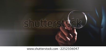 man holding a magnifying glass in his hands search for information