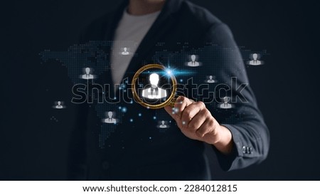 Man holding magnifying glass with working man icon, representing the HR concept. Human resources, recruitment, job search and talent acquisition in focus.