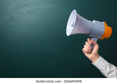 Man Holding Megaphone Near Chalkboard