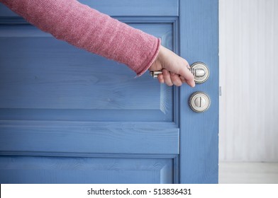 Man Holding A Metal Pen In An Open Wooden Door Blue