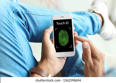 Man Holding Mobile Phone With Fingerprint Sensor, Closeup