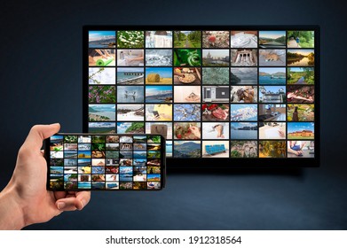 man holding mobile phone with many icons of video service on demand on background Oline TV VOD provider. Interface of video distribution service. Subscription Streaming video. Media TV on demand