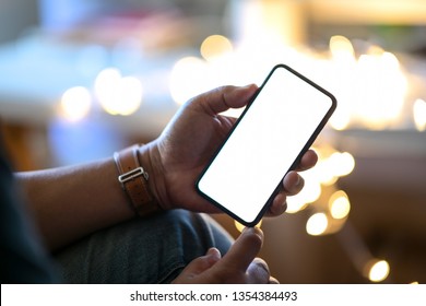 Man Holding Mobile Smart Phone At Street Night With Blurred Background	