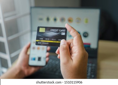 Man holding mock up credit card with number using smartphone and laptop computer for shopping.Online shopping concept.