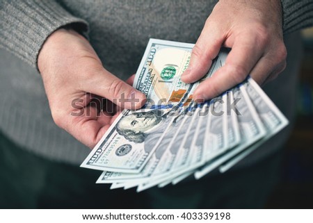 the man holding money dollars banknotes of one hundred