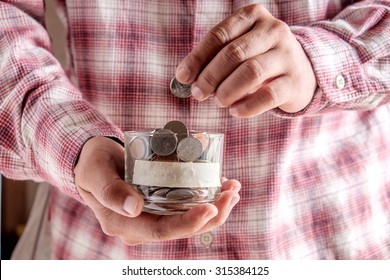 Man Holding Money Jar With Coins Close Up