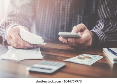 Man Holding Money And Using Mobile Phone Cash Paper And Coin Money