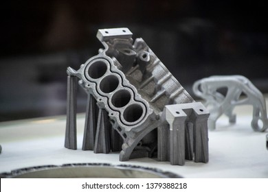 Man is holding object printed on metal 3d printer. Object printed in laser sintering machine. Modern 3D printer printing from metal powder. Progressive additive DMLS, SLM, SLS 3d printing technology
