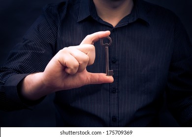 Man Holding An Old Key In Hand