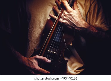 Man Is Holding An Old Violin, Closeup View On Body. 