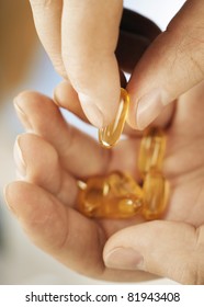 Man Holding Omega 3 Fish Oil Capsules In His Hands