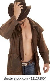 a man holding on to his western hat in his duster without a shirt.