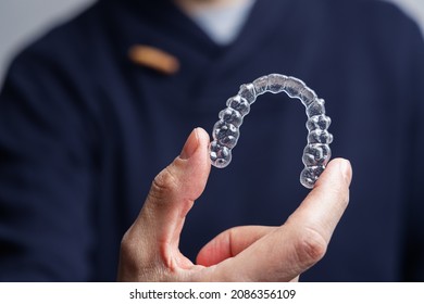 Man Holding One Transparent Aligner. Invisalign Orthodontics Concept