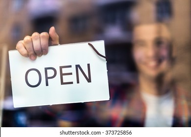 Man Holding Open Sign In Bike Shop
