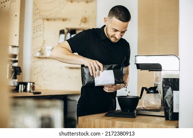 Man holding pack with coffee beans at the counter