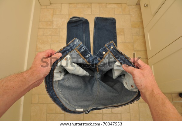 Man holding pants\
before putting them on