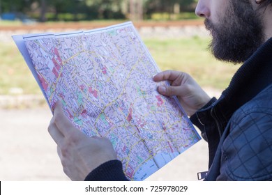 Man Holding A Paper Map In His Hands.