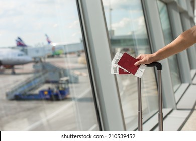 Man Holding Passports And Boarding Passport At Airport Waiting The Flight