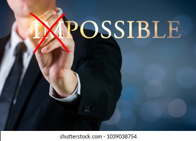 Man Holding A Pen To Cross Impossible Possible Word