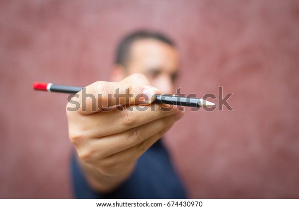 man holding up a\
pencil