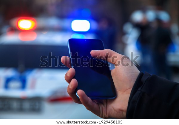 man holding phone\
with police in street\

