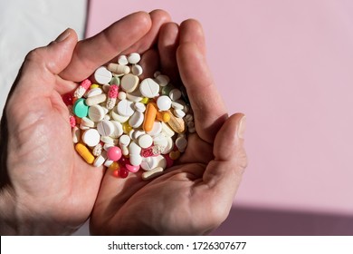 man holding pills on hand.Overdose of medication. A lot of pills spilled on table. Attempt of suicide.Economic crisis and medicine problems. Virus pandemic.Copy space