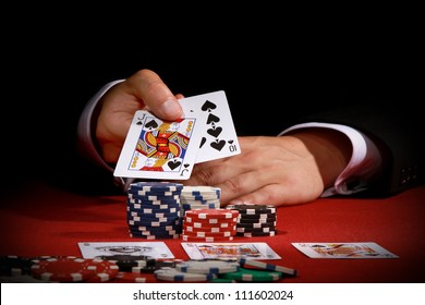 Man Holding Poker Cards On Red Background