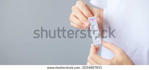 man holding Rapid Antigen Test kit\
with Negative result during swab COVID-19 testing. Coronavirus Self\
nasal or Home test, Lockdown and Home Isolation\
concept