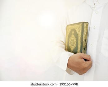 Man Holding And Reading Quran. Islamic Background. Arabic On The Text Translated With Quran