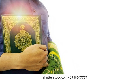 Man Holding and reading quran. Islamic Background. Arabic text on the cover translated with Quran