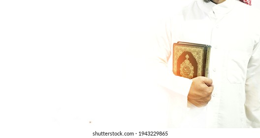 Man Holding and reading quran. Islamic Background. Arabic on the cover translated with Quran