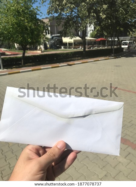 man holding a\
rectangular white envelope