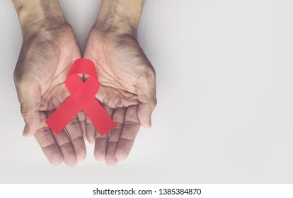 Man holding red aids ribbon, HIV/AIDS and aging awareness month concept