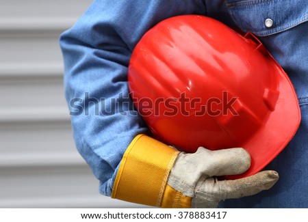 Man holding red helmet close up, shallow dof