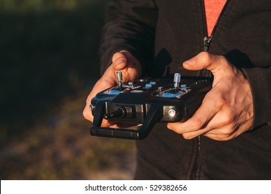 Man Holding Remote Controller In Hands Close-up. Male Hands Piloting Rc Car, Drone Or Helicopter. Pilot Running His Vehicle With Transmitter Outdoor, Free Space