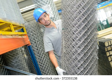 Man Holding Roll Of Metal Fencing Wire