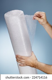 Man Holding A Roll Of Plastic Bubble Wrap.