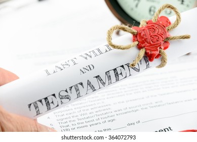 Man Holding A Rolled Up Scroll Of Last Will And Testament Fastened With Natural Brown Jute Twine Hemp Rope, Sealed With Sealing Wax And Stamped With Alphabet Letter B.