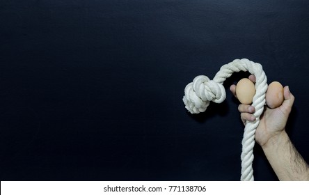 Man holding rope and two eggs showing erectile dysfunction