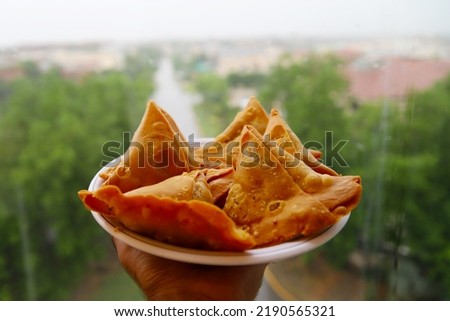 Man holding samosa  plate of   Spicy Indian or Pakistani snacks. Selective Focus on Subject, Background Blur.