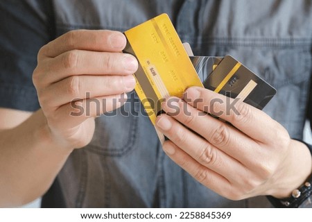 Man holding several credit cards and he is choosing a credit card to pay and spend Payment for goods via credit card. Finance and banking concept.