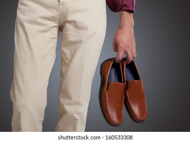 Man Holding The Shoes In Hand Close Up 