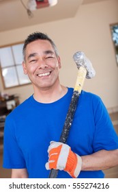 Man Holding Sledge Hammer In Garage