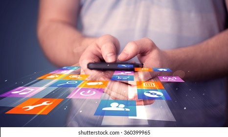 Man holding smart phone with colorful application icons comming out - Shutterstock ID 360399965