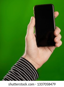 Man Holding A Smart Phone In Hand Over A Greenscreen Isolated Background